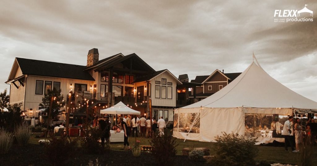 A backyard wedding with must-have party rentals like a large tent, market lighting, and outdoor furniture