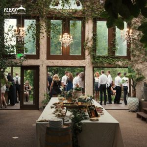 Wedding reception in a botanic garden structure with a natural linen-lined buffet table