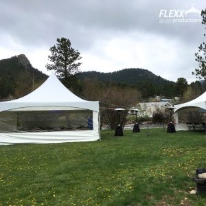 20x20 staked frame tents with heaters and market string lights at an outdoor riverside event