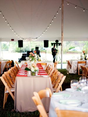 cad-layout-tent-setup Tables and chairs draped in vibrant linen tablecloths with place settings in front of a stage at a wedding