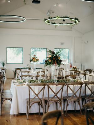 wedding-rental-options Beautiful napa wood table setting at a wedding with white linen tablecloth, glassware, and other wedding rentals
