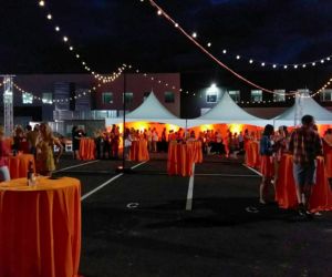 Orange linen rentals covering tables set up for an outdoor event