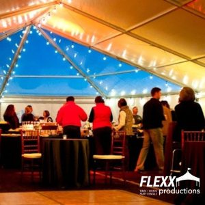 Market string lighting displayed in a wedding tent with a clear aspe end