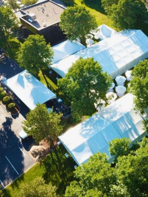 tent-rentals-for-nonprofit-events Overhead view of medium and large tent rentals and tables with umbrellas set up at an outdoor charity event