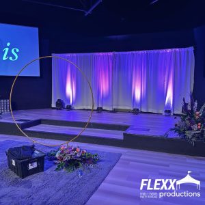 Pipe and drape set up on a stage to accentuate lighting elements