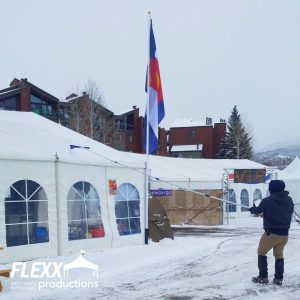 Tech removing snow from a tent at a winter festival