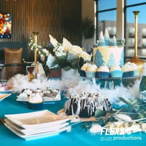 Turquoise and white holiday table setting with different desserts, dessert plates, and other goodies