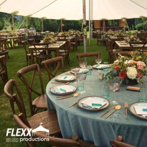Wedding with decorated tables and chairs under a tidewater tent rental